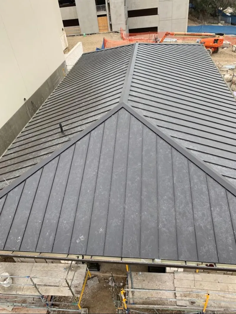 Commercial metal roof construction with crane equipment in Omaha